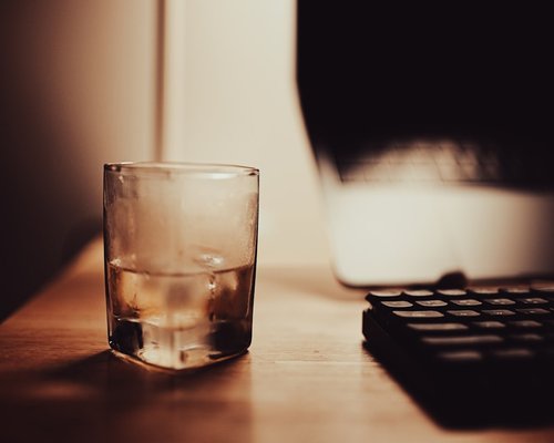 Glass of water next to a keyboard
