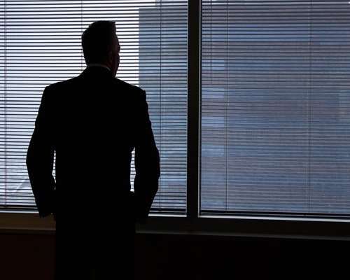 Person looking out of a window in an office building